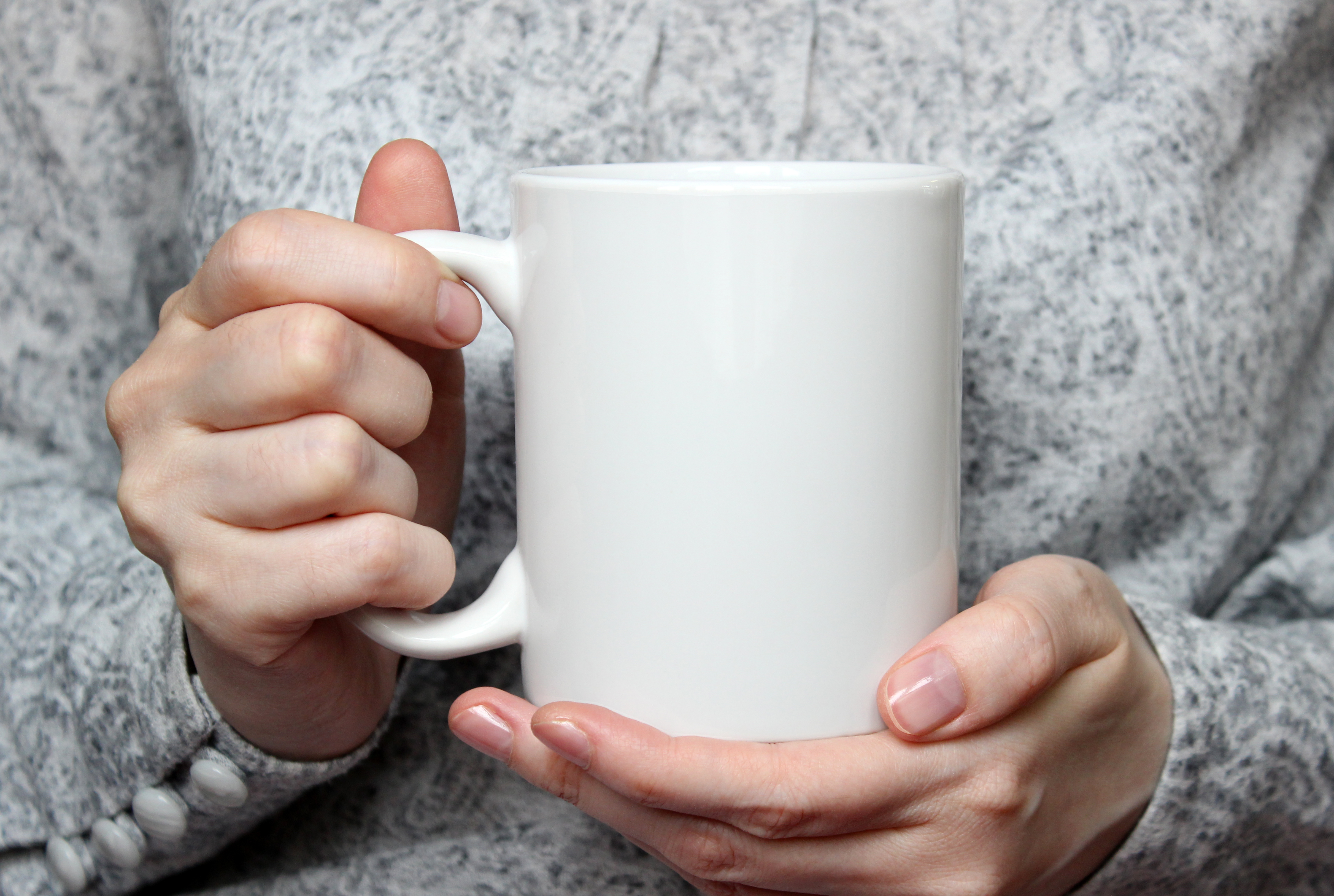 Close up of a woman holding a white mug
